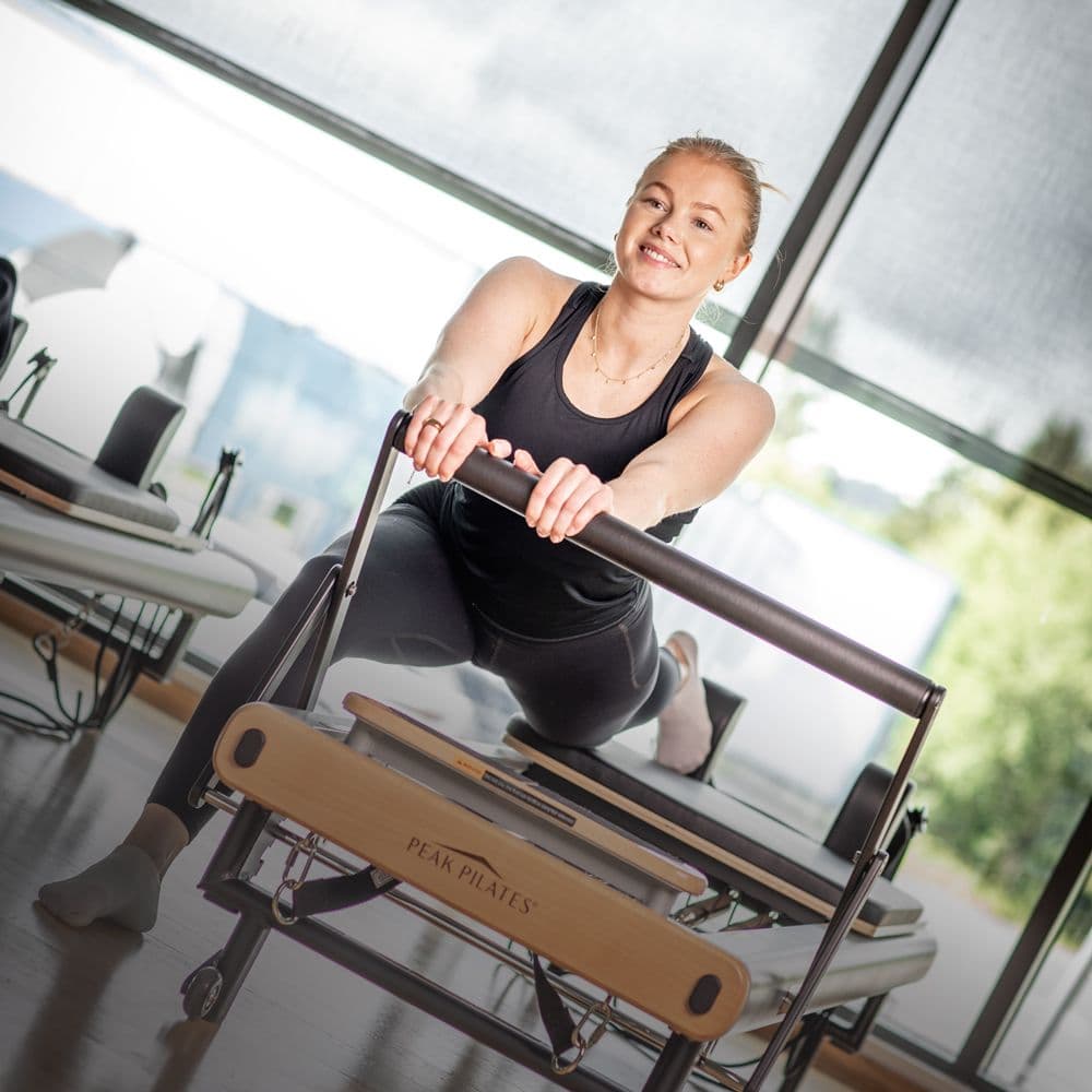 En jente som gjør Pilates på en Reformer-maskin på 3T-Treningssenter