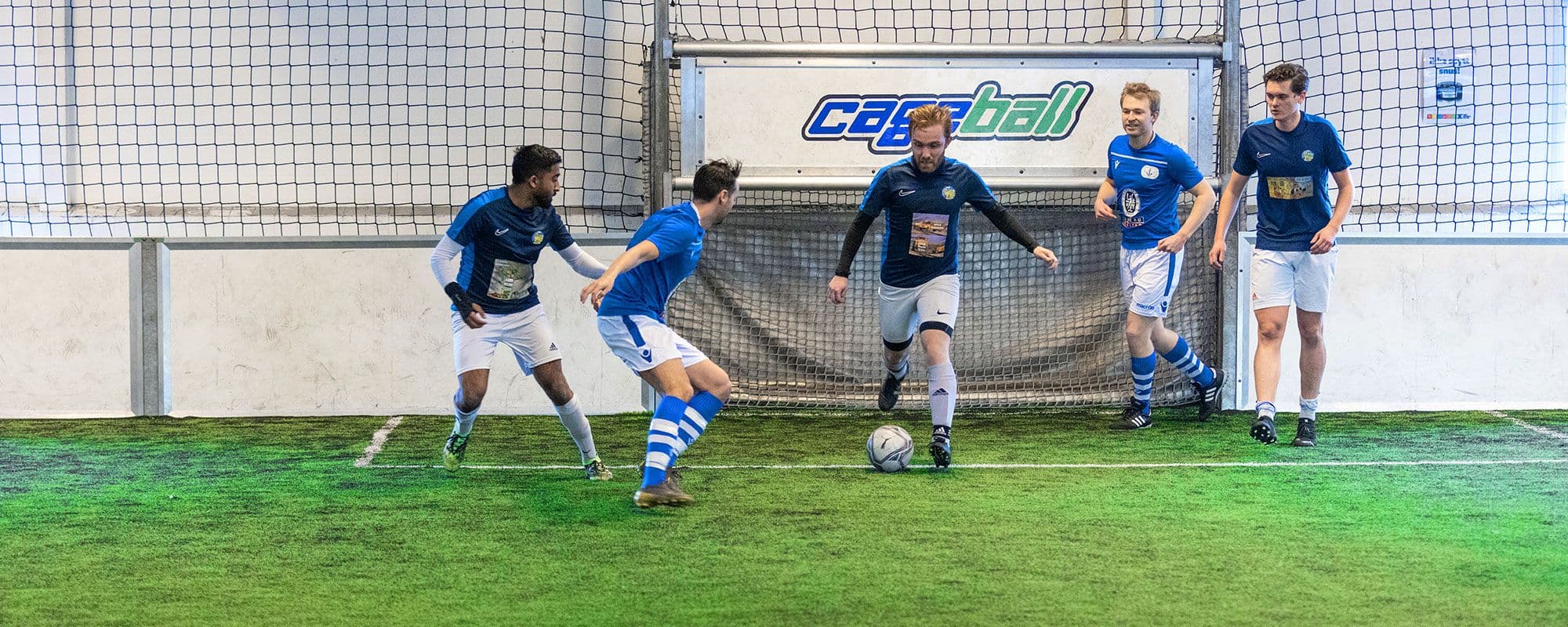 Fotballspill foran mål, inne på Cageball Rosten.