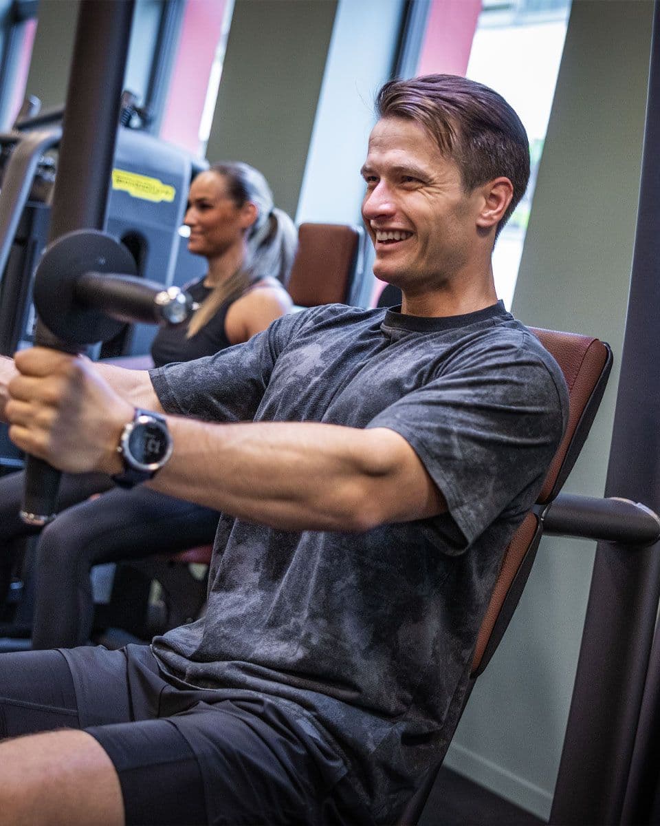 mann som trener styrke i et apparat på 3T-Teknostallen