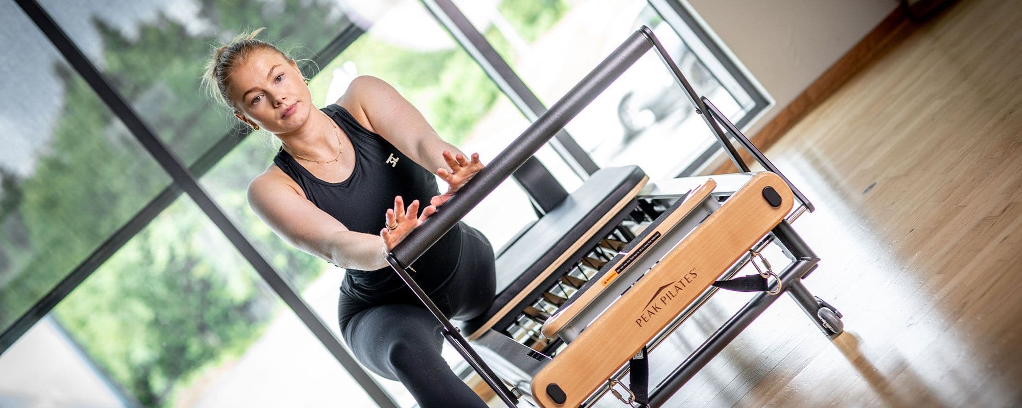 En jente som gjør Pilates på en Reformer-maskin på 3T-Treningssenter